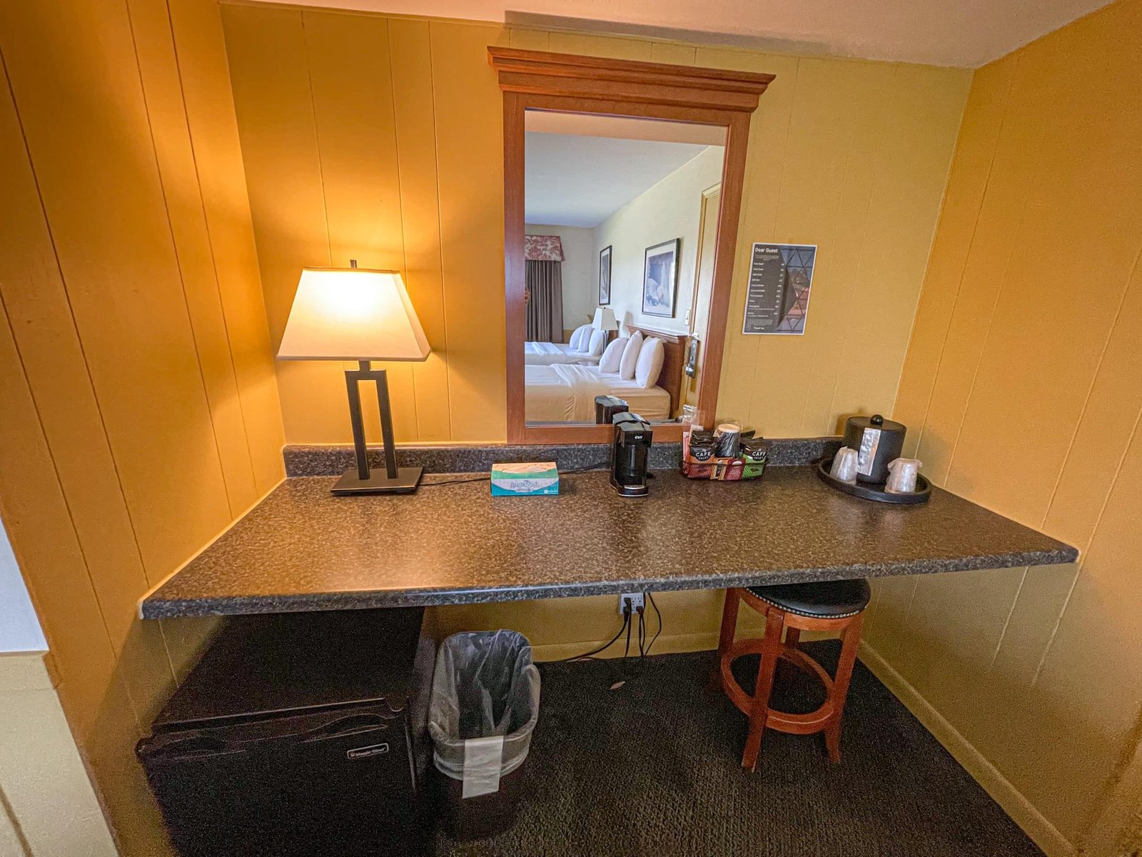 Hotel room workspace with coffee maker, flat-screen TV, and a plush seating area, reflecting the comfort and amenities of Blue Spruce Lodge at Otsego Resort.