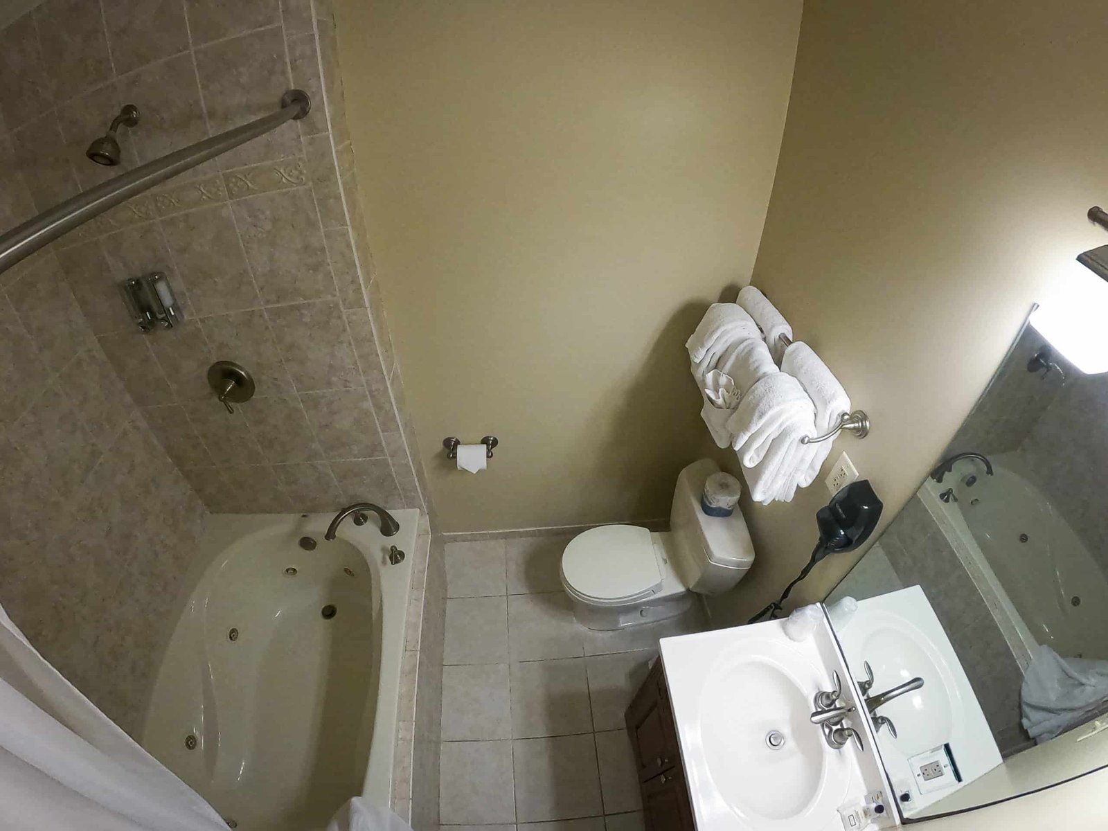 Spacious bathroom featuring an oversized tub with jets, shower, large vanity, and plush towels at Otsego Resort chalet.