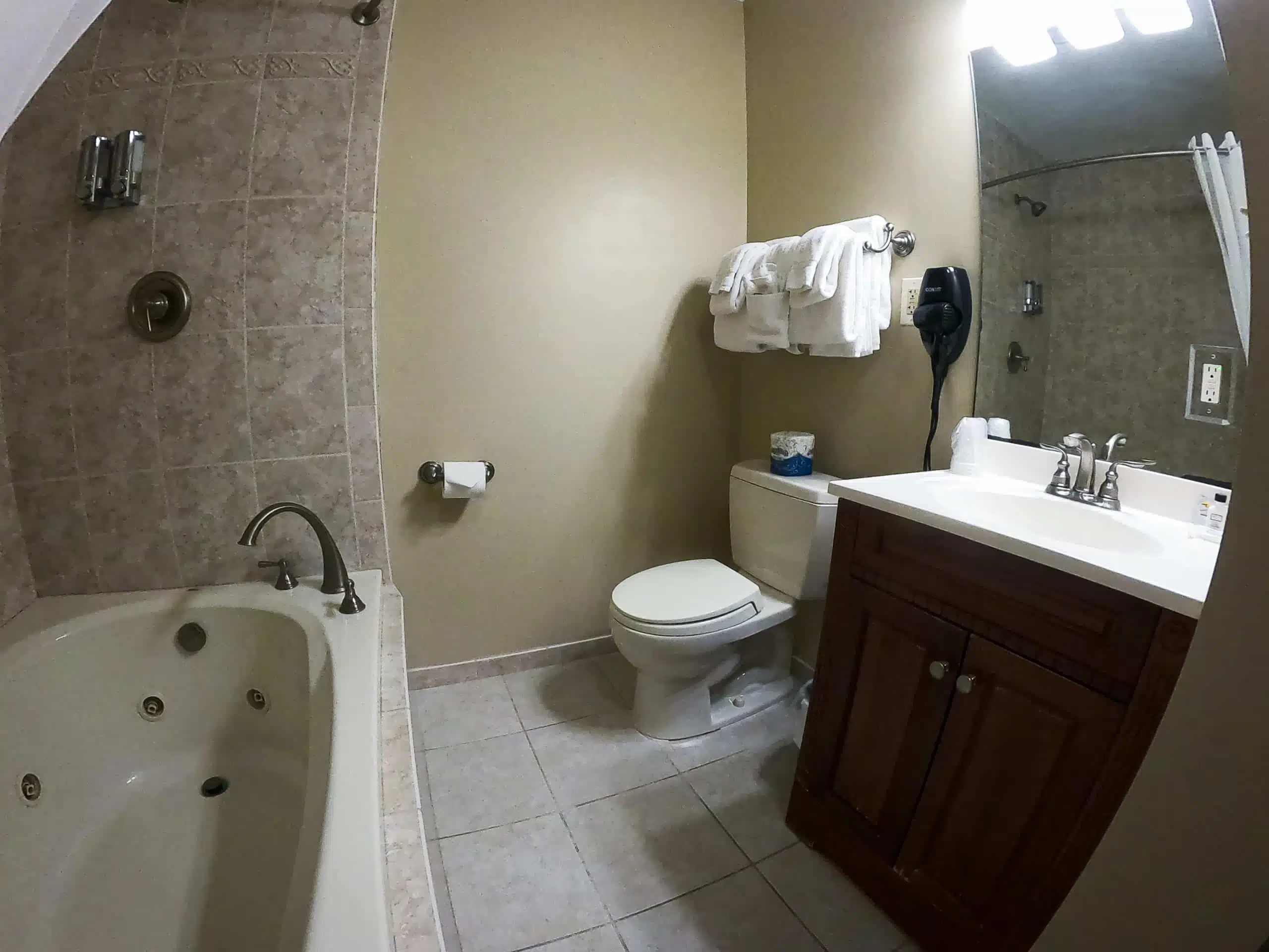 Bathroom with oversized tub, shower, and vanity featuring spa amenities at Otsego Resort chalet.