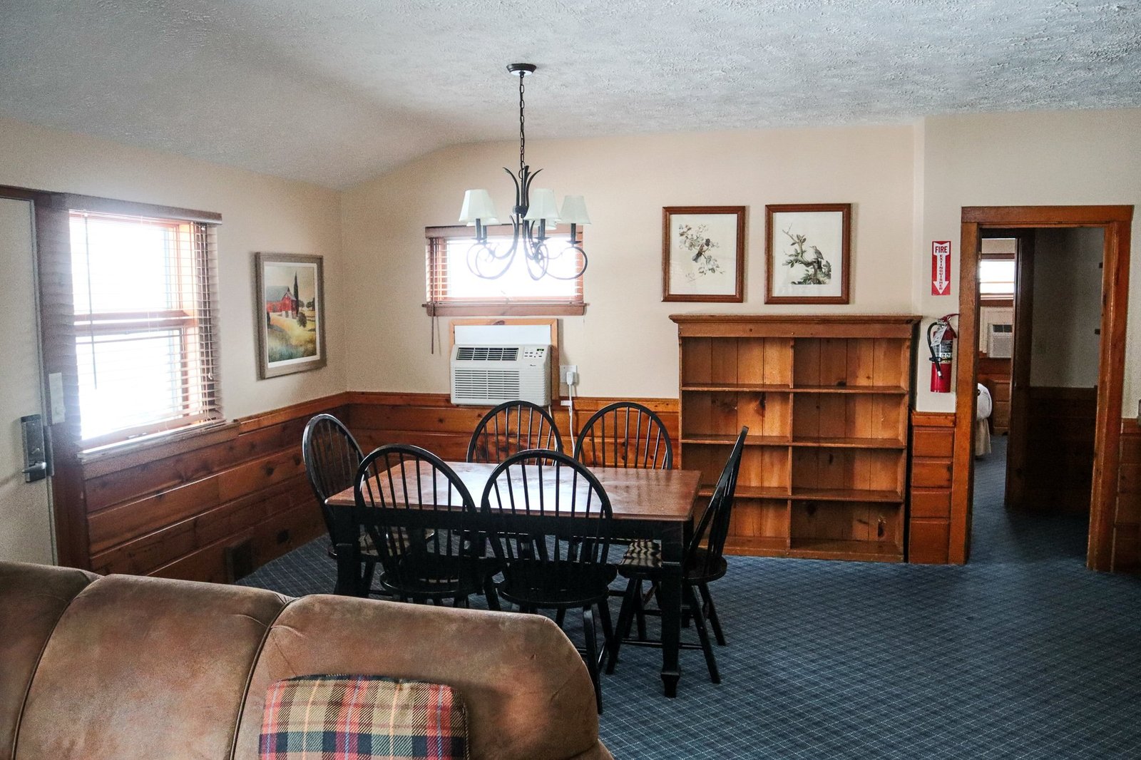 Spacious chalet living room with dining table, wooden decor, and air conditioning, showcasing amenities for guests at Otsego Resort.