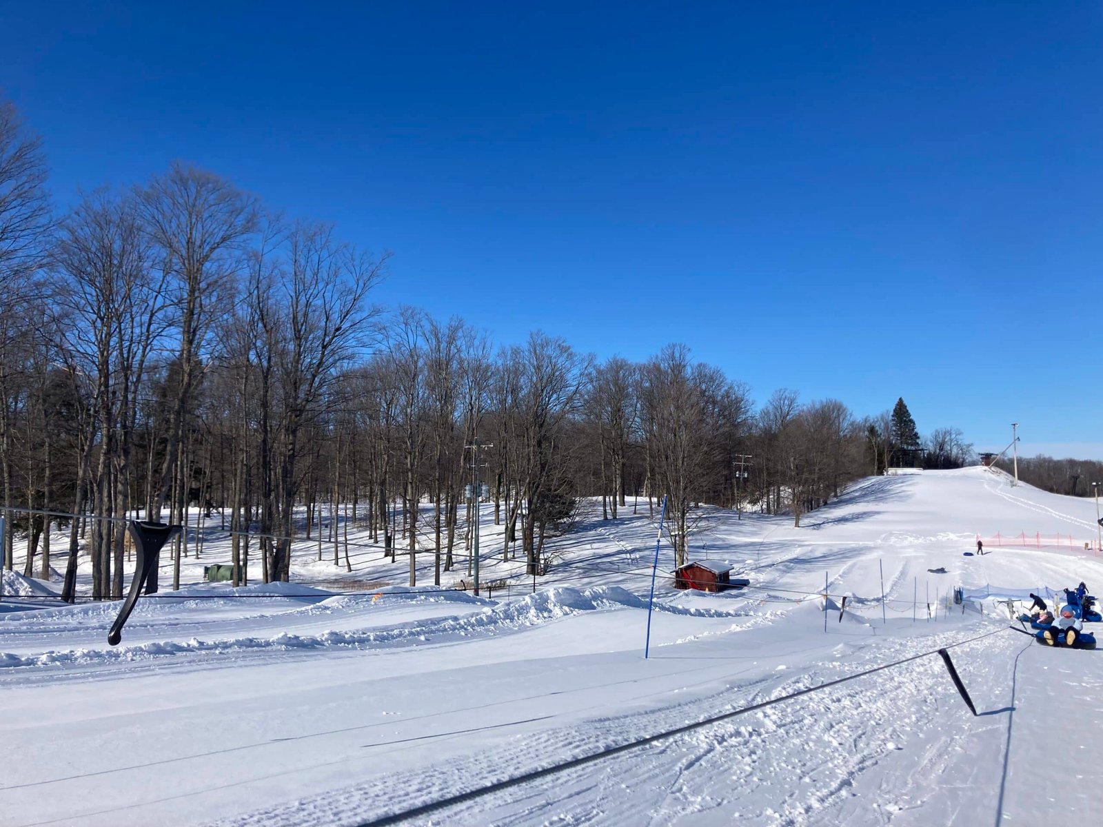 Ski slopes at Otsego Resort with snow-covered terrain, trees, and a clear blue sky, showcasing winter sports opportunities in Northern Michigan.